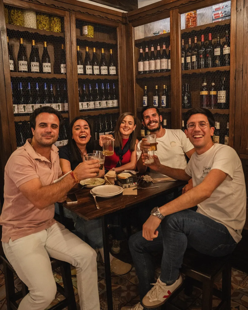 La bodega de la taberna, con las botellas en sus vitrinas de madera