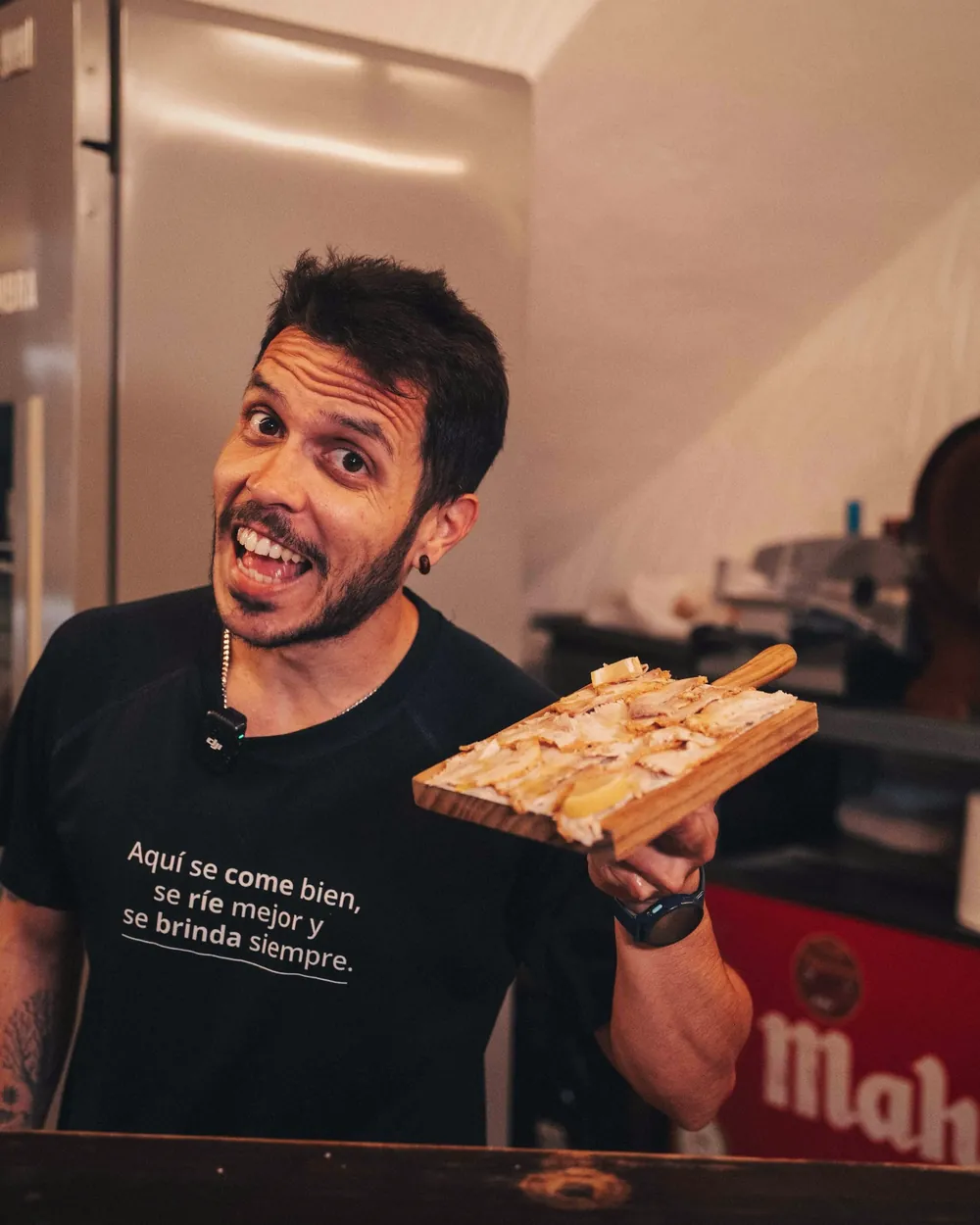 Cocinero de L'Aspilla con una tosta y la camiseta «Aquí se come bien, se ríe mejor y se brinda siempre»